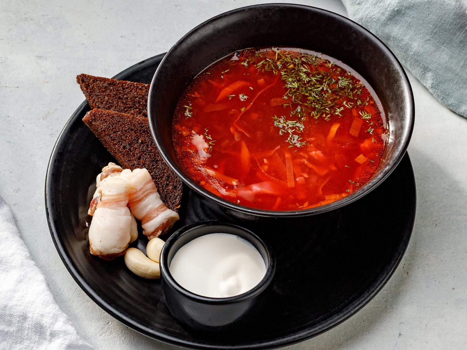 Домашний борщ с соленым и копченым салом, гренками из бородинского хлеба и чесноком